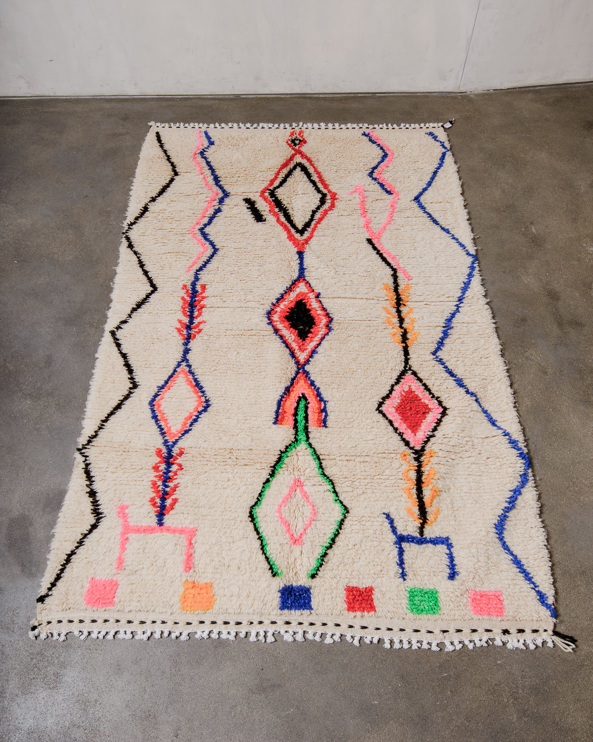 Berberlin Azilal rug made of fluffy wool and cotton, laying flat on a concrete floor.